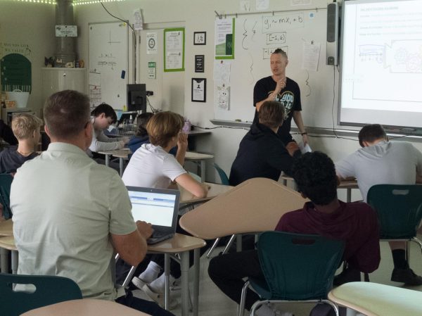 Associate principal Ben Chiri quietly observes Mr. Rivers' class and notes down his observations.